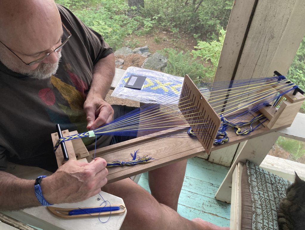 Don weaving on a loom he designed